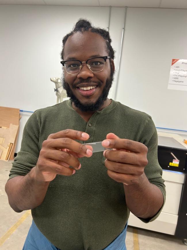 A freshly laser-cut acrylic coverslip held up
