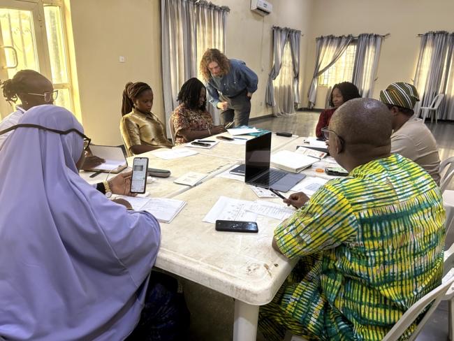 The research team gathered around a table in Abeokuta, reviewing the study plan together