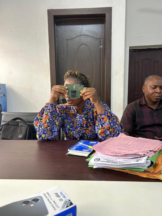 Oluwanifemi looking through a Foldscope